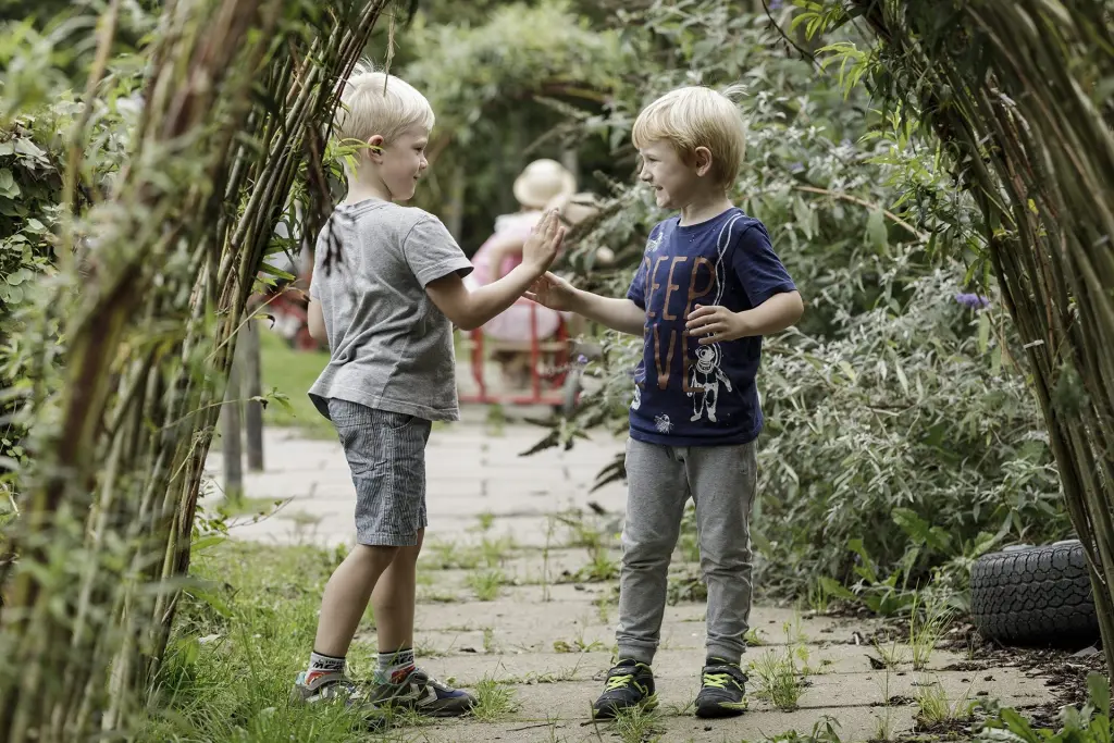 To drenge giver hinanden high five i piletunnellen.